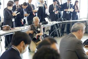 新潟水俣病の被害者団体と浅尾慶一郎環境相の懇談の場で撮影する小原王明さん。「しっかり記録を残したい」と語る=5月31日、新潟市中央区
