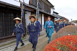 江戸時代の旅装束で「御金荷の道」を歩くイベントの参加者=長野県東御市