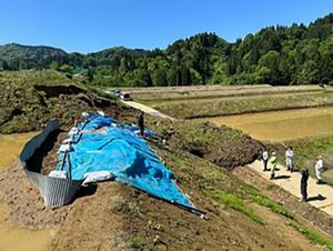 能登半島地震で生じた亀裂に水が染み込んで崩落したとみられる水田のり面=5月14日、上越市清里区