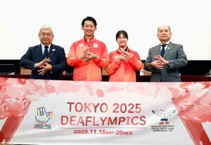 記者会見でポーズをとる(左から)日本選手団の太田陽介団長、旗手の松元卓巳、小倉涼、全日本ろうあ連盟の石橋大吾理事長=16日、東京・内幸町の日本記者クラブ