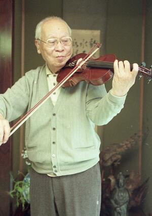 愛用のバイオリンを弾く植木周三さん。戦中も、戦後も音楽とともにあった=1995年、新潟市の自宅