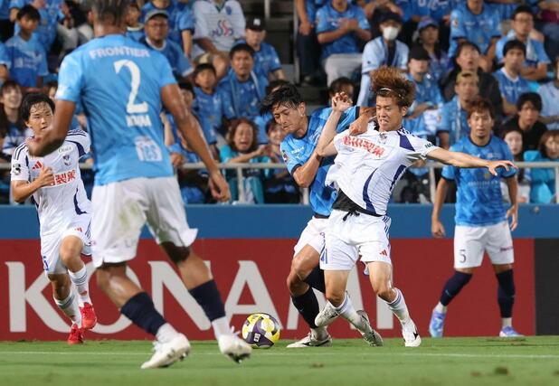 前半、相手の激しい守備に合う新潟の長谷川元希＝ニッパツ三ツ沢球技場