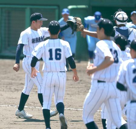加茂暁星－新潟産大付　最後の打者を三振に打ち取り、捕手とハイタッチする新潟産大付先発の和栗玲旺（左）＝長岡市悠久山球場