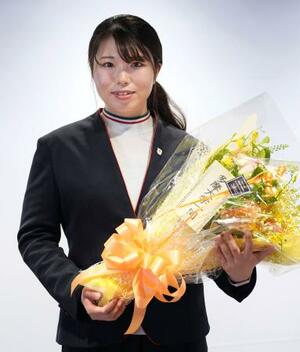 　花束を手にポーズをとるフリースタイルスキー女子モーグルの冨高日向子＝２９日、東京都多摩市
