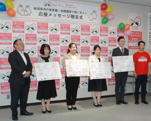 新潟県と日本生命からメッセージボードを受け取った県内の保育園長ら=6月5日、新潟市中央区