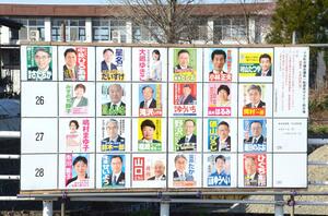 十日町市川西地域に立つ市議選の掲示板。25人の候補の選挙ポスターが並ぶ