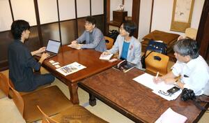 TREEを視察し、代表の中川裕稀さん(左から1人目)から説明を受ける地域再生大賞の選考委員ら=三条市仲之町