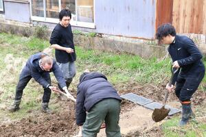 農作業する「岩室シェアハウスとも家」の米作りのメンバーたち=新潟市西蒲区岩室温泉