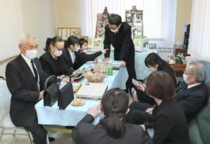 笠原平治さんの葬儀前に集まった親族。思い出の詰まった家族写真に笑顔がこぼれる=新潟市西区