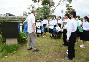 平和記念公園で上越日豪協会の関勝代表の話を聞く名立中生徒=上越市川原町