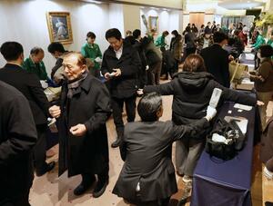 演説会場で来場者の手荷物検査などをする警察官ら＝２日、上越市