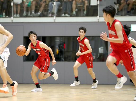 男子決勝トーナメント１回戦　実践学園－本丸　第２クオーター、攻め上がる本丸の相馬遼大（左）ら＝アオーレ長岡