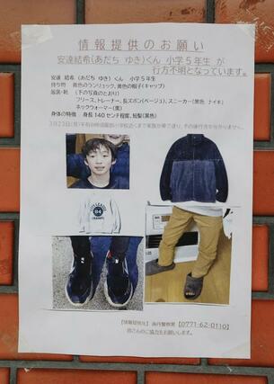 京都府南丹市内に掲示された、安達結希さんの情報を求める張り紙＝１３日午後