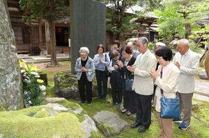 県内で27年ぶりとなる「日連丸事件」法要開催を前に会場の徳昌寺を訪れ、慰霊碑に手を合わせる遺族ら=長岡市与板町与板