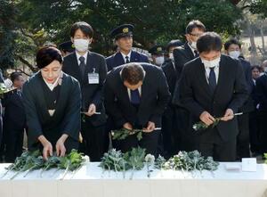 　茨城県北茨城市の展望慰霊塔前で開かれた追悼式で献花する参列者＝１１日午後