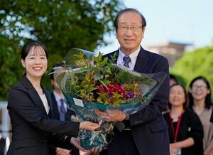 ノーベル化学賞の受賞決定から一夜明け、職員から花束を受け取る京都大の北川進氏(右)=9日午前、京都市左京区