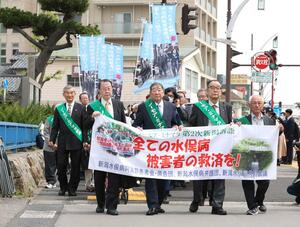地裁判決を前に、中村洋二郎さん(右から2人目)を先頭に入廷行進する新潟水俣病第5次訴訟の原告や支援者ら=2024年4月、新潟市中央区
