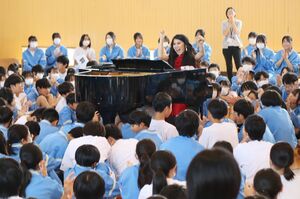 ピアノを囲んだ生徒たちにジャズ曲を披露する山本真純さん=長岡市巻島町