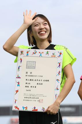 成年女子走り幅跳び決勝　５位入賞した権瓶明日夏（高清）が賞状を片手に笑顔を見せる＝佐賀市