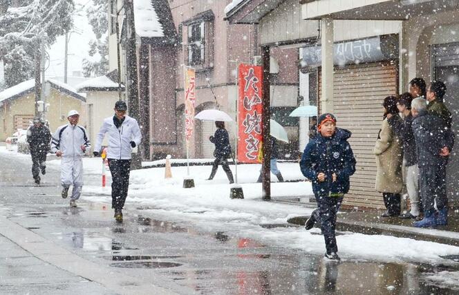 
雪や寒風をものともせず、駆け抜ける元旦マラソンの参加者＝１月１日、魚沼市堀之内
