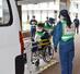 特別養護老人ホームの要支援者役を福祉車両から降ろす、防災訓練の参加者＝９日、村上市