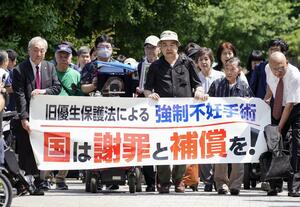 旧優生保護法違憲訴訟の上告審判決で、横断幕を手に最高裁に向かう原告と弁護団ら=7月3日午後