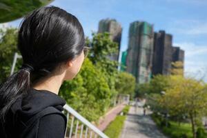 火災があった日まで両親と暮らしていた高層住宅群「宏福苑」を見つめる呉欣樺さん=28日、香港北部・新界地区大埔(共同)