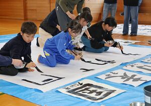大きな用紙に漢字を書く子どもたち=南魚沼市市野江