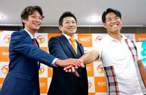 東京都議選で当選を決めた望月正謹氏(左)、最上佳則氏(右)と写真に納まる参政党の神谷代表=23日未明、東京・赤坂の党本部
