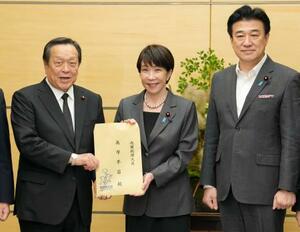 　安保関連３文書の改定に向けた提言を、自民党の浜田靖一安全保障調査会長（左）から受け取る高市首相。右は木原官房長官＝２４日午後、首相官邸