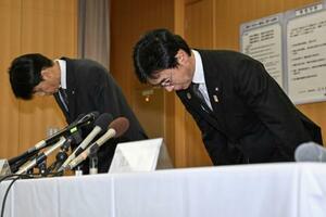 記者会見で謝罪し、頭を下げる大阪メトロの堀元治交通事業本部長(右)ら=14日午前、大阪市西区