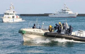小型ボートで海上に逃走したテロリストをゴムボートで挟み込み制圧した訓練=佐渡市の小木港