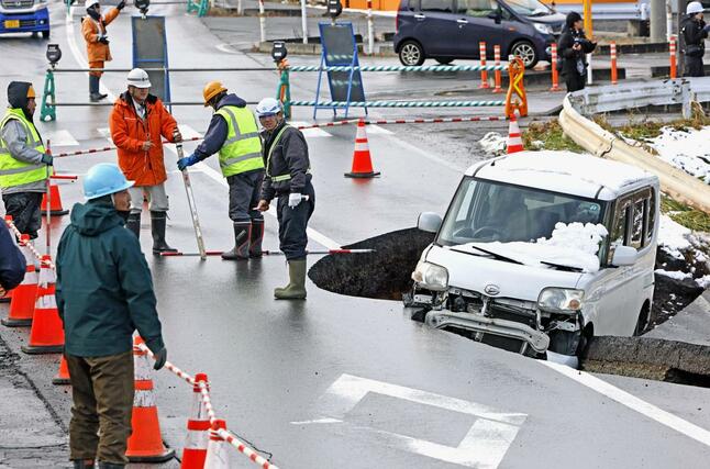 強い地震があった青森県東北町の陥没した道路と車両＝９日午後０時５分