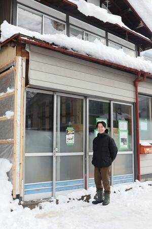 軒の灯の建物の前に立つ國部智之さん＝湯沢町湯沢