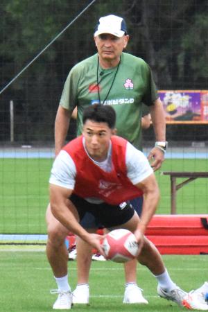 練習を見守るラグビー日本代表のジョーンズ・ヘッドコーチ(奥)=22日、宮崎市