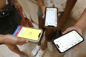 　オーストラリアで１６歳未満のＳＮＳ利用を禁止する法律が施行された後に、スマートフォンでＳＮＳを見る子どもたち＝７日、シドニー（共同）