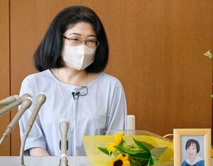 追悼礼拝後、取材に応じる鷹野めぐみさん。写真は亡くなった矢吹恵さん=26日午後、東京都町田市