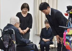 亡き妻が不妊手術を強制された被害者だった小林宝二さん(左)に謝罪する兵庫県の斎藤元彦知事=26日午後、神戸市中央区