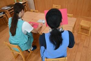 職員(左)と一緒に作業する単発バイトの女性保育士=9月、東京都内の保育園