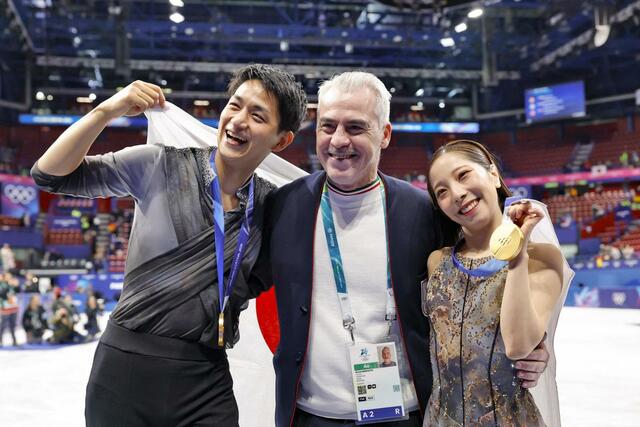 ペアで金メダルを獲得し、ブルーノ・マルコット・コーチ（中央）と記念撮影する三浦璃来（右）、木原龍一組＝ミラノ（共同）