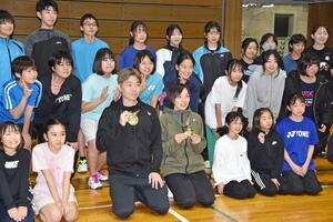 金メダルを手に子どもたちと記念撮影する沼倉昌明さんと千紘さん＝長岡市学校町１