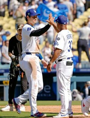 パドレスに勝利し、ロバーツ監督(右)とタッチを交わすドジャース・大谷=ロサンゼルス(共同)