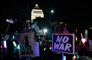 国会前で開かれた平和憲法の維持を求める市民団体の集会=8日夜