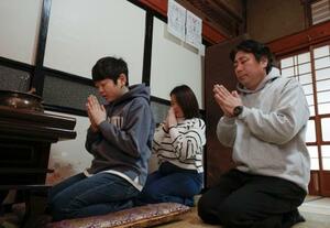　佐藤すえ子さん（奥）の実家で長女未空さん、長男択海さんの仏壇に手を合わせる夫の英夫さん、次男生望さん＝２月、宮城県石巻市