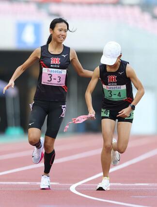 新潟明訓の３区山崎夢夏（左）が４区日下部結唯にタスキを渡す＝新潟市中央区