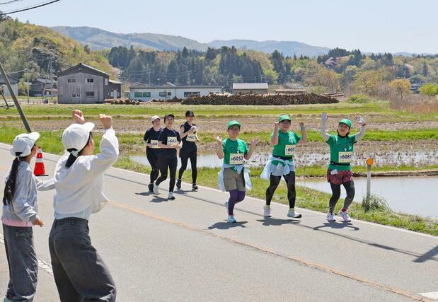 佐渡トキマラソンで沿道から住民の応援を受けながら走るランナー＝２６日、佐渡市