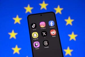 スマートフォンのSNSアプリとEU旗(ロイター=共同)