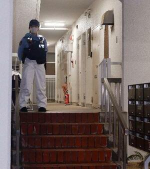 冷凍庫に入った男性の遺体が見つかった集合住宅を警戒する警察官=20日午後9時26分、神戸市中央区
