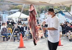 多くの来場者の前で行われたアンコウのつるし切り＝出雲崎町尼瀬