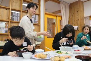 地元食材を使った昼食を食べる見学会参加者ら=佐渡市鷲崎
